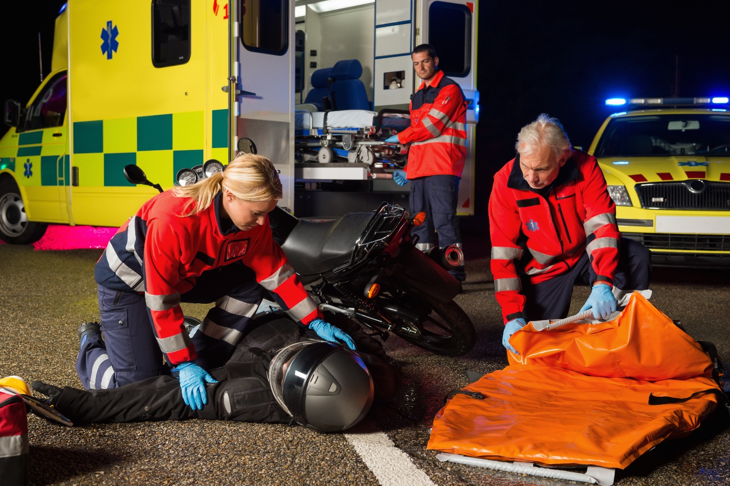 emergency team helping injured motorbike driver