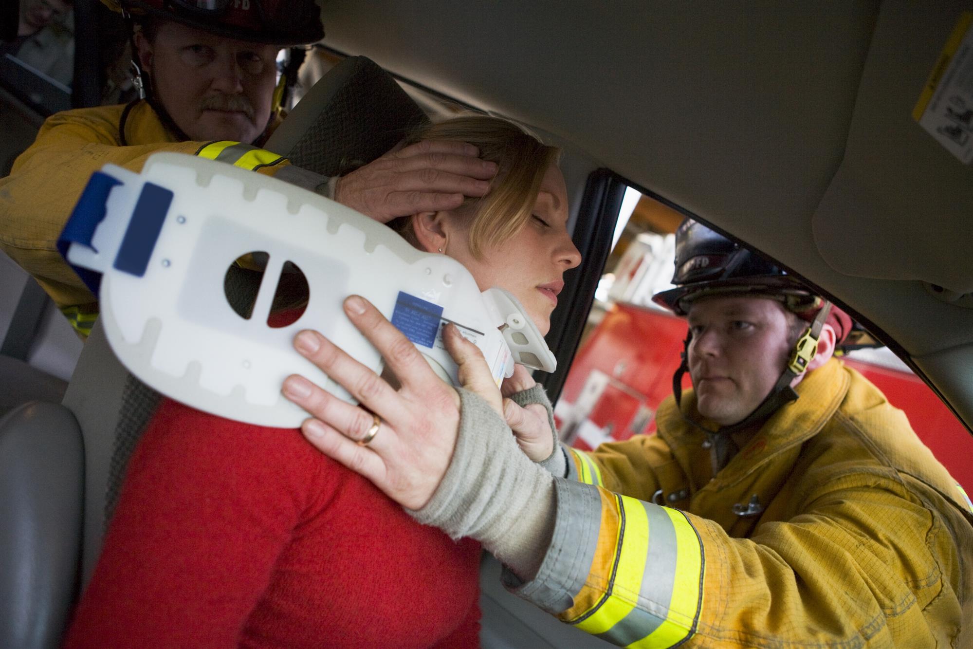 firemen helping woman with neck brace